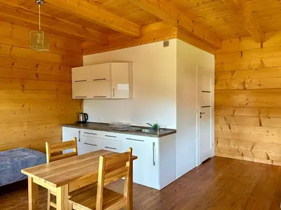 a kitchen with a table and a dining room at Domki góralskie na Podhalu Zakopane in Tokarnia