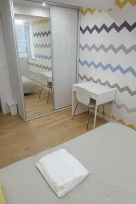 a bedroom with a mirror and a table and a bed at Three Rooms Apartment in Kraków