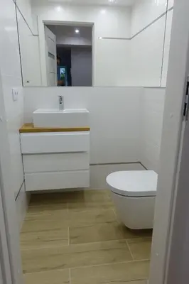a white bathroom with a toilet and a sink at Three Rooms Apartment in Kraków