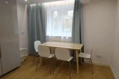 a table and chairs in a room with a window at Three Rooms Apartment in Kraków