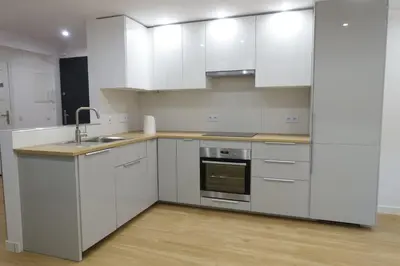 a kitchen with white cabinets and a sink at Three Rooms Apartment in Kraków