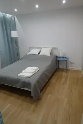 a bedroom with a bed and a wooden floor at Three Rooms Apartment in Kraków
