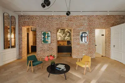 a room with a brick wall and chairs and a table at LaRry BirD Old Town by WillyWalls in Kraków