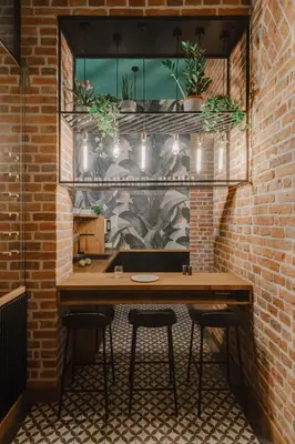 a brick wall with a table and some plants at LaRry BirD Old Town by WillyWalls in Kraków