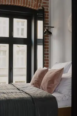 a bedroom with a bed with pillows and a window at LaRry BirD Old Town by WillyWalls in Kraków