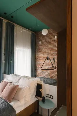 a bedroom with a bed and a brick wall at LaRry BirD Old Town by WillyWalls in Kraków