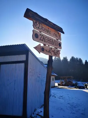 a street sign in the snow next to a building at Domki na Zagroniu in Koninki
