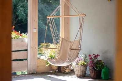 a hammock hanging on a porch with potted plants at Przystanek Leśna-3 Apartamenty nad potokiem w sercu natury in Targanice