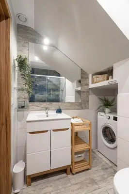 a bathroom with a sink and a washing machine at Przystanek Leśna-3 Apartamenty nad potokiem w sercu natury in Targanice