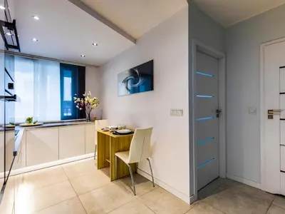 a kitchen and dining room with a table and a window at Jack II Apartment in Kraków