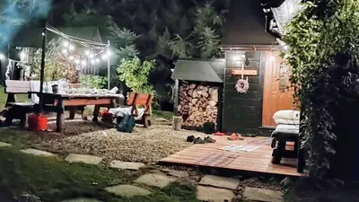 a backyard at night with a table and a barbecue at Beskidzka Ostoja in Koszarawa