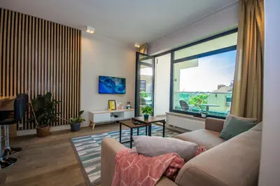 a living room with a couch and a large window at InPoint Executive Apartments near Old Town & Kazimierz District in Kraków