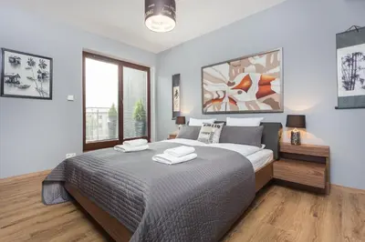 a bedroom with a large bed and a large window at InPoint Executive Apartments near Old Town & Kazimierz District in Kraków