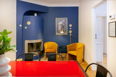 a dining room with blue walls and yellow chairs at Prime Location Apartment in Kraków