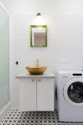 a bathroom with a sink and a washing machine at Prime Location Apartment in Kraków