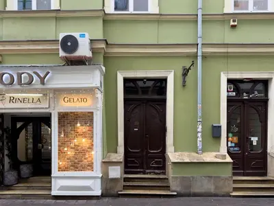 a green building with two doors and a store at Prime Location Apartment in Kraków