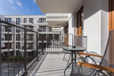 a balcony with a table and chairs and a building at City of the Kings - Smile Apartment in Kraków