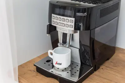 a coffee machine with a cup on a stand at City of the Kings - Smile Apartment in Kraków