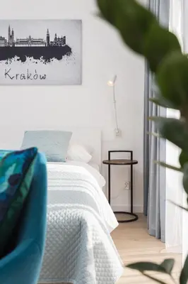 a bedroom with a bed and a painting on the wall at City of the Kings - Smile Apartment in Kraków