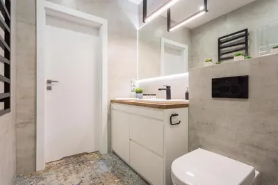 a bathroom with a white toilet and a sink at City of the Kings - Smile Apartment in Kraków