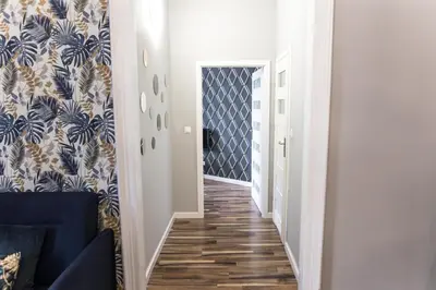 a hallway with a blue and white patterned wall at CracWoW Old Town Apartment in Kraków