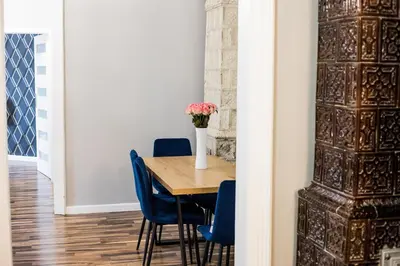 a dining room table with blue chairs and a vase with flowers at CracWoW Old Town Apartment in Kraków