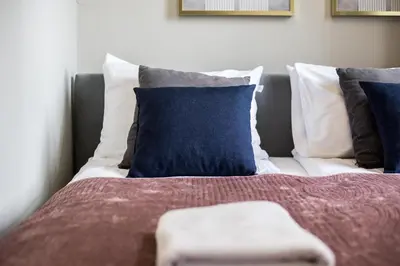 a bed with blue and white pillows on it at CracWoW Old Town Apartment in Kraków