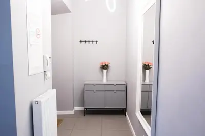 a bathroom with white walls and a mirror at CracWoW Old Town Apartment in Kraków