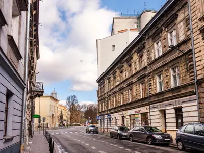 a city street with cars parked on the street at CracWoW Old Town Apartment in Kraków