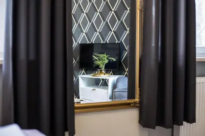 a mirror in a room with a tv and a chair at CracWoW Old Town Apartment in Kraków