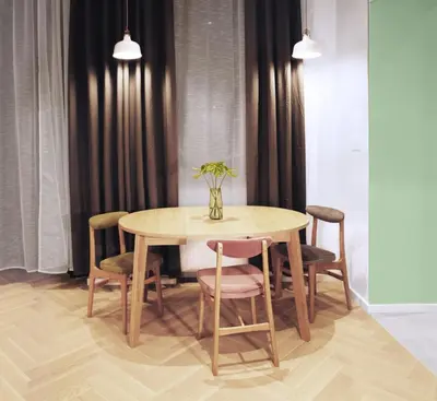 a dining room table with chairs and a vase with flowers at Apartament LIMANO in Kraków