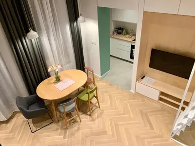 a kitchen and dining room with a table and chairs at Apartament LIMANO in Kraków