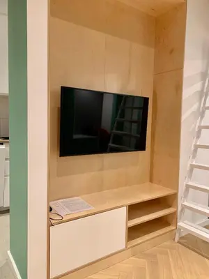 a living room with a tv in a wall at Apartament LIMANO in Kraków