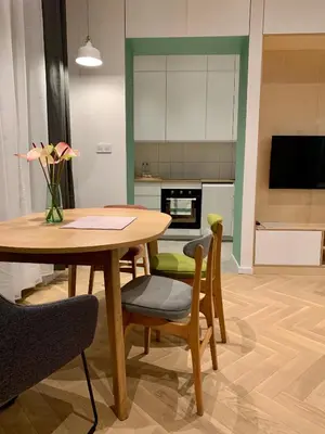 a kitchen and dining room with a table and chairs at Apartament LIMANO in Kraków