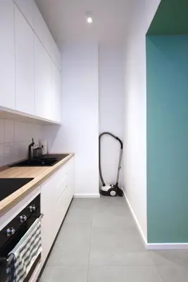 a kitchen with white cabinets and a vacuum at Apartament LIMANO in Kraków
