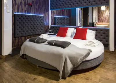 a large bed with red pillows in a room at Yourplace Romantic Apartment with private patio in Kraków