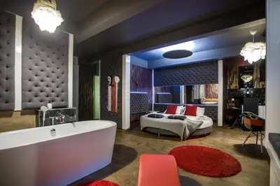 a bathroom with a tub and a bed in a room at Yourplace Romantic Apartment with private patio in Kraków