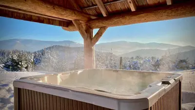 a hot tub in a room with a mountain view at Osada Beskidzka in Zawoja