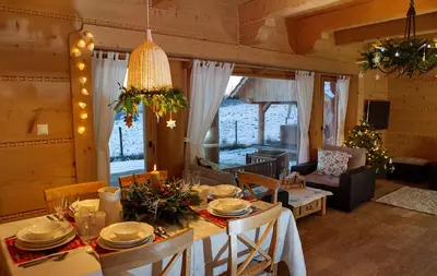 a living room with a dining room table with christmas decorations at Osada Beskidzka in Zawoja