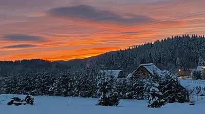 a sunset over a ski lodge in the snow at Osada Beskidzka in Zawoja