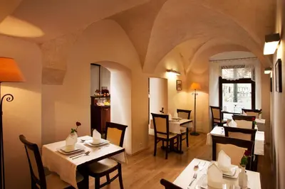 a dining room with tables and chairs in a restaurant at Hotel Santi in Kraków