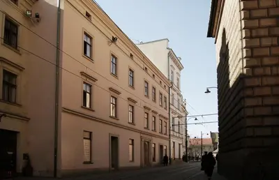 a person walking down a street between two buildings at Hotel Santi in Kraków