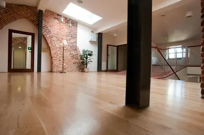 an empty room with a wooden floor and a brick wall at Hotel Santi in Kraków