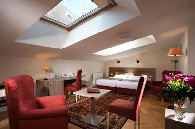a bedroom with a bed and a table and chairs at Hotel Santi in Kraków