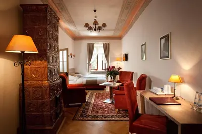 a living room with a desk and a room with a bed at Hotel Santi in Kraków