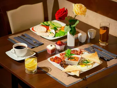 a table with two plates of food and a cup of coffee at Hotel Santi in Kraków