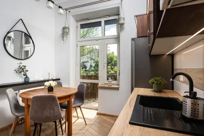 a kitchen and dining room with a table and a window at Classy Old Town Apartment - by Upstairs in Kraków