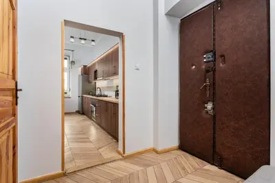 a room with a door and a kitchen with a counter at Classy Old Town Apartment - by Upstairs in Kraków