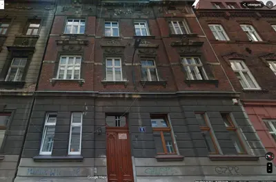 a tall brick building with red doors and windows at Classy Old Town Apartment - by Upstairs in Kraków