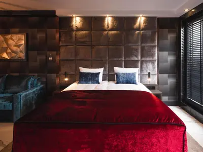a bedroom with a large bed with a red blanket at Art Suites Boutique Hotel - Krakow Center in Kraków